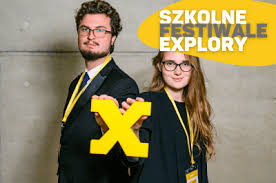 Dwoje ludzi stoi do siebie plecami. Obok nich jest napis "Szkolne festiwale explory"
