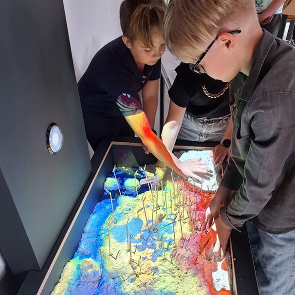Na zdjęciu widać chłopców eksperymentujących przy eksponacie Usyp mapę.